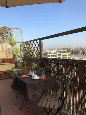 a table and chairs on a balcony with a view at Atticoromantica in Rome
