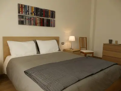 a bedroom with a bed and a shelf of dvds at Atticoromantica in Rome