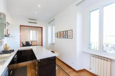 a kitchen with white walls and a large window at Ripa by Rental in Rome in Rome