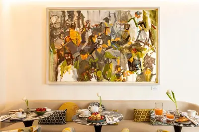 a painting hanging on a wall above two tables at Nerva Boutique Hotel in Rome