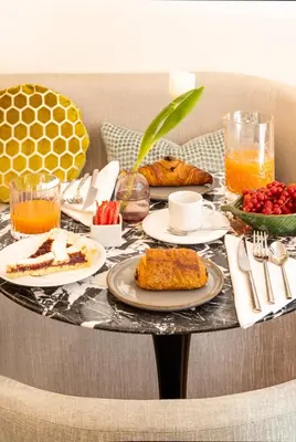 a table with plates of food and drinks on it at Nerva Boutique Hotel in Rome