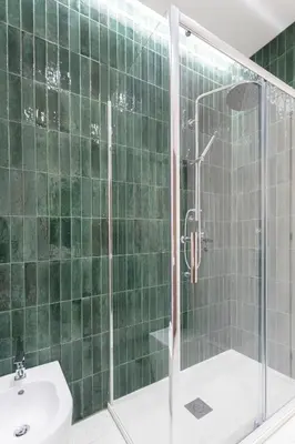 a green tiled bathroom with a shower and a sink at Carlotta Stylish Apartment Close Tiburtina Station in Rome
