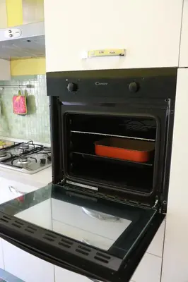 an open oven in a kitchen next to a stove at Laura's Apartment Vatican in Rome