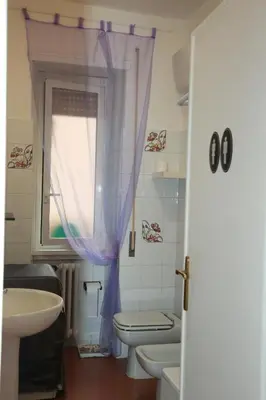 a bathroom with a sink and a toilet and a window at Laura's Apartment Vatican in Rome