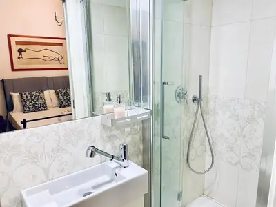 a bathroom with a glass shower and a sink at Cozy Flat near the Vatican! in Rome