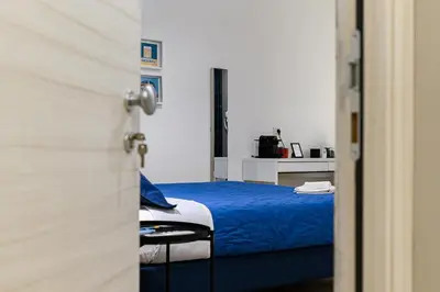 a bedroom with a blue bed and a table at Del Frate Guest House Vatican in Rome