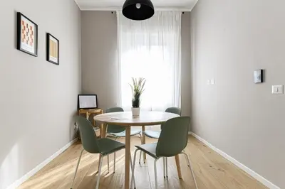 a dining room with a table and green chairs at Del Frate Guest House Vatican in Rome