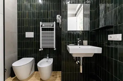 a green tiled bathroom with a toilet and a sink at Del Frate Guest House Vatican in Rome