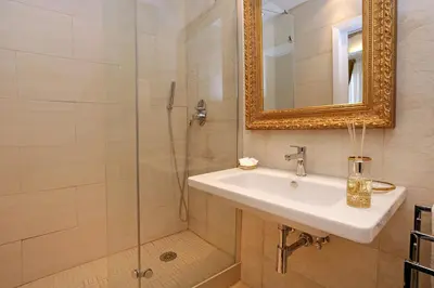 a bathroom with a sink and a shower with a mirror at Madonna de' Monti Suites in Rome