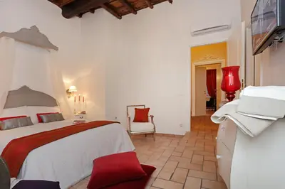 a hotel room with a bed and a tv at Madonna de' Monti Suites in Rome