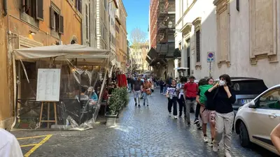 a group of people walking down a street at Madonna de' Monti Suites in Rome