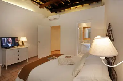 a bedroom with a bed with a lamp and a television at Madonna de' Monti Suites in Rome