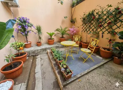 a table and two chairs sitting next to a wall at Casa Domus Mea - garden addicted in Rome