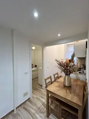 a dining room with a table and a vase of flowers at Casa Domus Mea - garden addicted in Rome