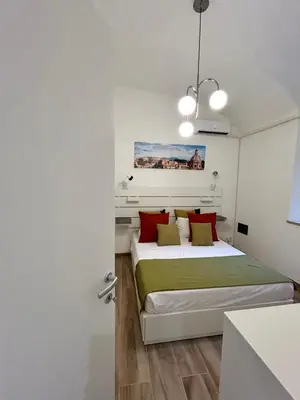 a bedroom with a bed with red and green pillows at Casa Domus Mea - garden addicted in Rome