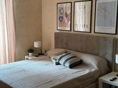 a bedroom with a bed with four pictures on the wall at Campani Termini Apartment in Rome