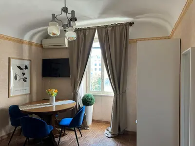 a dining room with a table and chairs and a window at Campani Termini Apartment in Rome