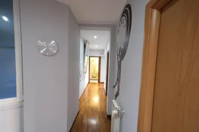 a hallway with white walls and a clock on the wall at Roman Forum Holiday Termini in Rome
