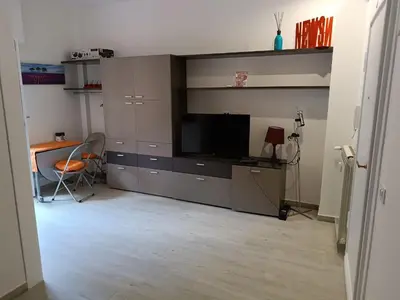 a living room with a large entertainment center with a flat screen tv at Vatican tiny house by Gialel in Rome