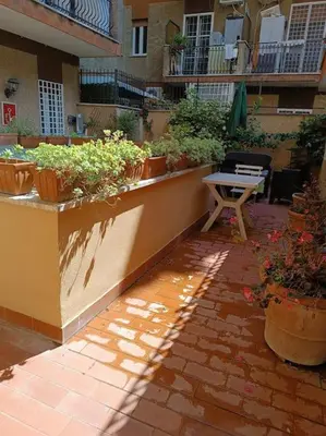 a patio with a table and potted plants at Vatican tiny house by Gialel in Rome