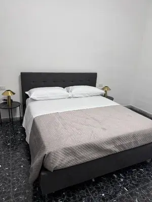 a bedroom with a large bed with white sheets and pillows at LarisaSuite in Rome