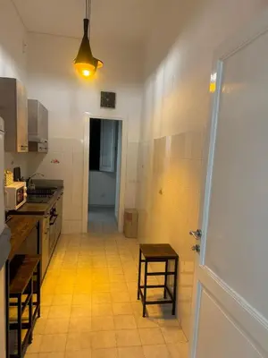 a kitchen with a door leading to a hallway at LarisaSuite in Rome