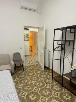 a living room with a bed and a chair at LarisaSuite in Rome