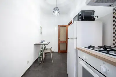 a kitchen with a white refrigerator and a table at Dream suite Modern in Rome Air Conditioning WiFi near the Metro A in Rome