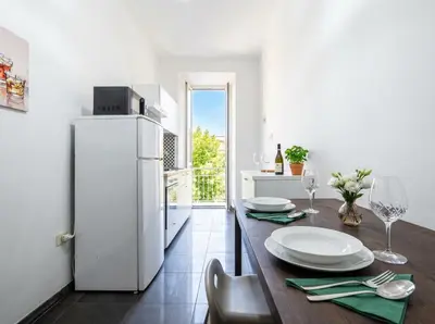 a kitchen with a wooden table with a white refrigerator at Dream suite Modern in Rome Air Conditioning WiFi near the Metro A in Rome