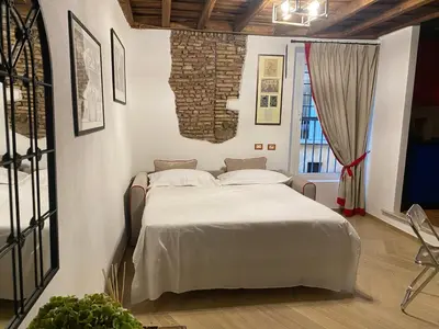 a bedroom with a bed with a brick wall at Pantheon Appartamento Costaguti in Rome
