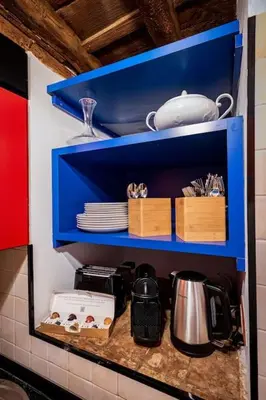 a blue shelf in a kitchen with plates and utensils at Pantheon Appartamento Costaguti in Rome