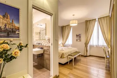 a bedroom with a bed and a sink and a mirror at Gravina Suite Frattina in Rome