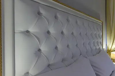 a white headboard of a bed in a room at Gravina Suite Frattina in Rome