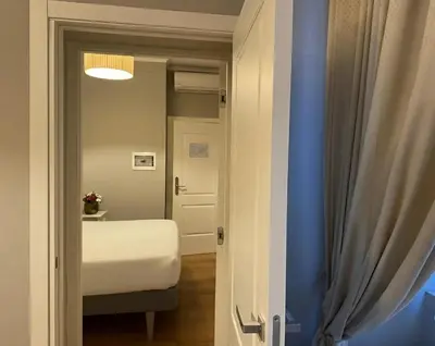 a small room with a bed and a door at Gravina Suite Frattina in Rome