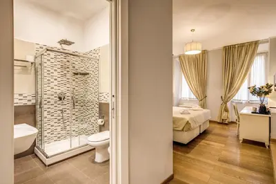 a bathroom with a toilet and a shower and a bed at Gravina Suite Frattina in Rome