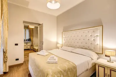 a bedroom with a large bed with a large headboard at Gravina Suite Frattina in Rome
