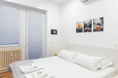 a white bedroom with a bed and a window at Casetta Pandosia - San Giovanni - Colosseo in Rome