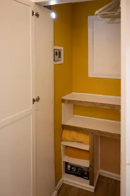 a closet with yellow walls and white cabinets at A bridge to the Coliseum in Rome