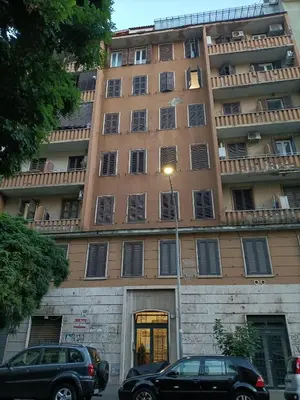 a large building with cars parked in front of it at A bridge to the Coliseum in Rome
