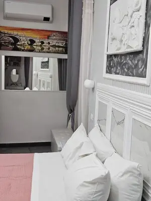 a bedroom with a bed with white pillows and a mirror at A&F Colosseo in Rome