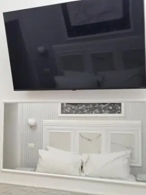 a flat screen tv above a bed with white pillows at A&F Colosseo in Rome