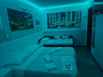 a blue room with two beds and a couch at A&F Colosseo in Rome