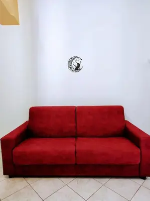 a red couch sitting against a white wall at Notti di San Lorenzo in Rome