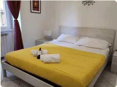 a large yellow bed with two towels on it at Notti di San Lorenzo in Rome