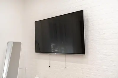 a white living room with a desk and a television at Emm Maison Rome in Rome
