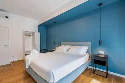 a bedroom with a large bed with a blue wall at Relais Garbatella in Rome