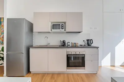 a kitchen with white cabinets and a microwave at Relais Garbatella in Rome