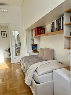 a bedroom with a bed in a white room at Sunrise House - San Giovanni in Rome