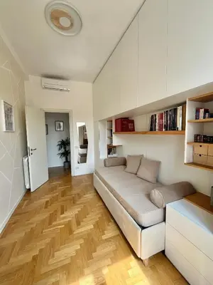 a living room with a couch and wooden floors at Sunrise House - San Giovanni in Rome