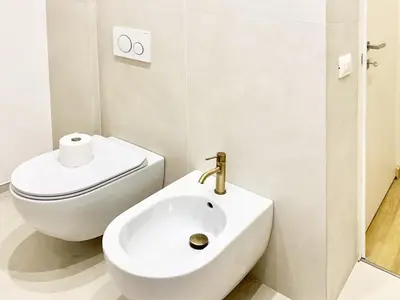 a white bathroom with a toilet and a sink at DaliTourism - Nazionale Charme in Rome